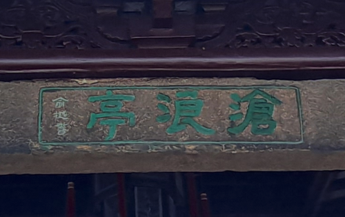 Wooden pavilion roof beam with three Chinese characters carved into it